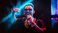 a man in sunglasses singing into a microphone