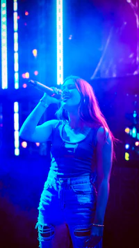 a woman singing into a microphone at a concert