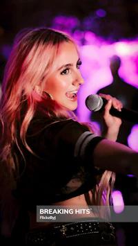 a blonde woman singing into a microphone