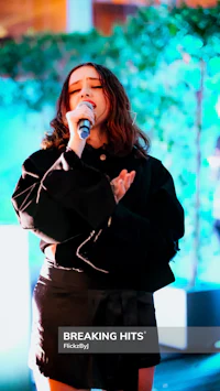 a woman singing into a microphone at an event