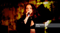 a woman singing into a microphone at a concert