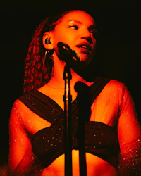 a woman in a black top singing into a microphone